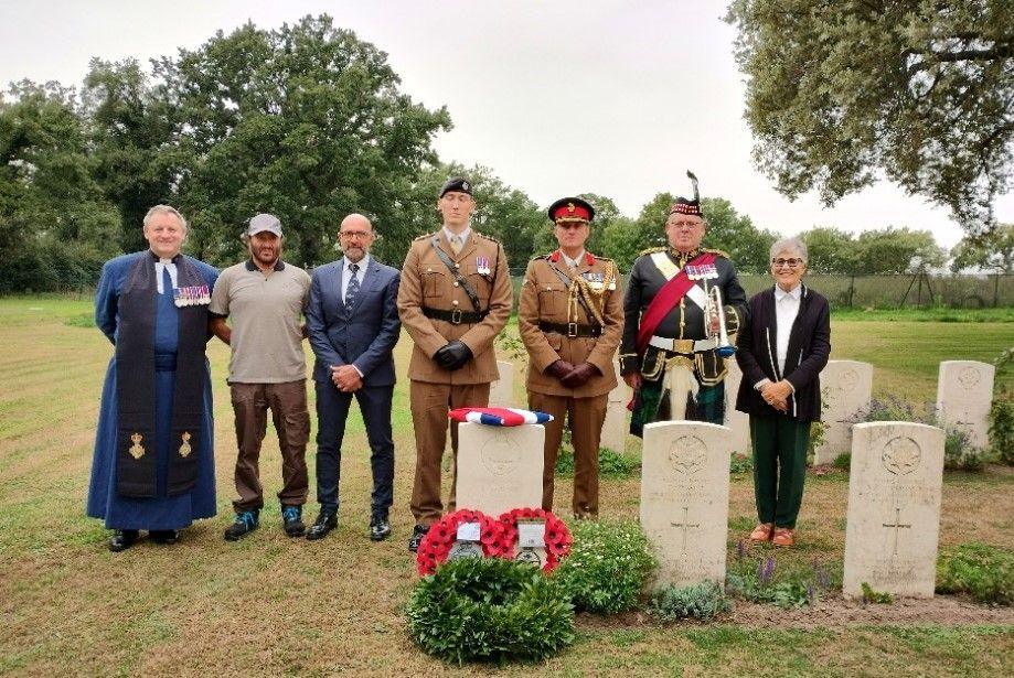 The military party, representatives of the CWGC, and the researcher who submitted the original identification case for Tpr Stobart, stand behind his headstone in Italy. A wreath of poppies and the Union Jack are laid by the headstone.