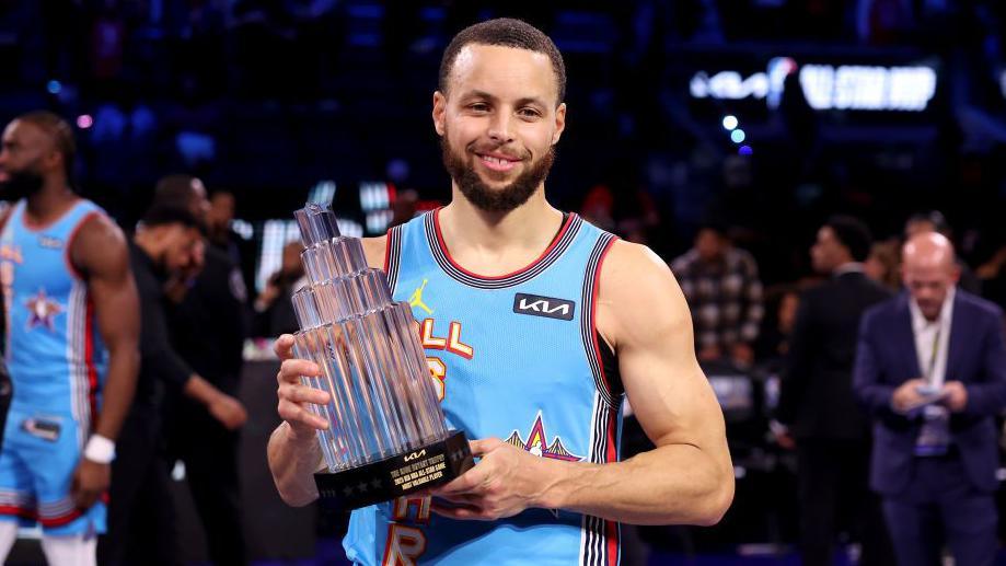 Steph Curry holds the Kobe Bryant MVP trophy