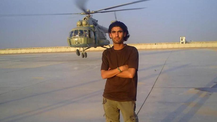 Wali in front of a helicopter