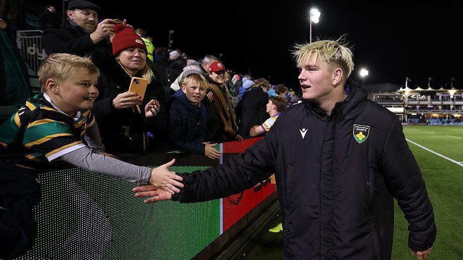 Northampton star Henry Pollock greets a Saints fan after the team's win over Bath at the Rec in December