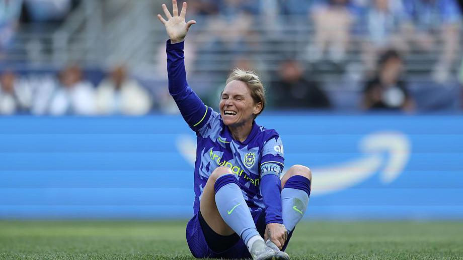 Jess Fishlock clutches her ankle on the pitch 