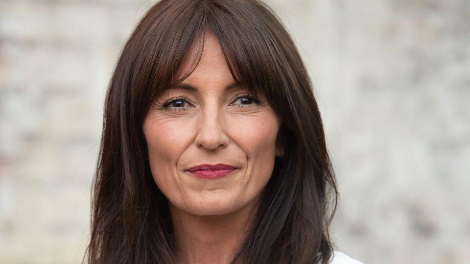 Davina McCall wearing white and looking ahead