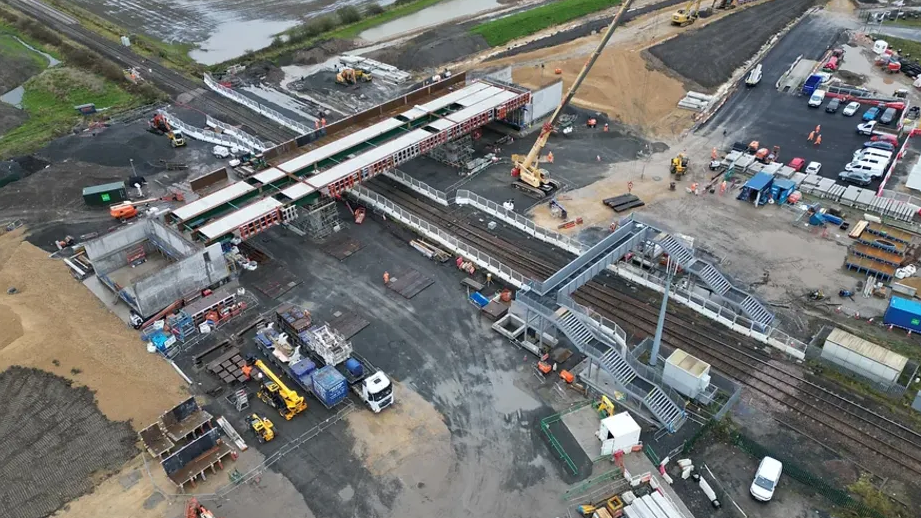 An overhead shot of construction work on railway line, with trucks and cranes in action.