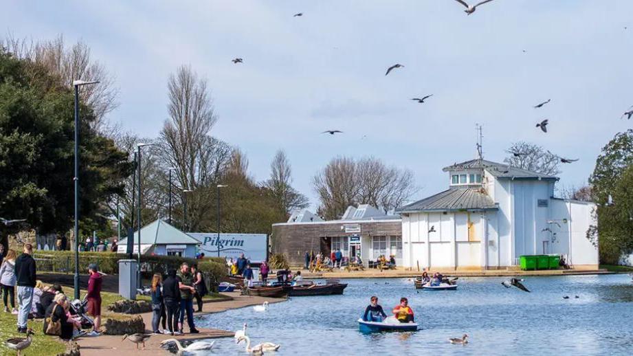 Cleethorpes boating like. People are enjoying a day out on and beside teh water.