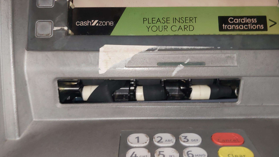 Photo showing an ATM with what appears to be a black device intended to scan card details attached to it