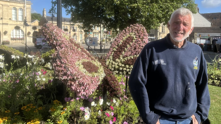 Richard Collett standing beside the floral butterfly