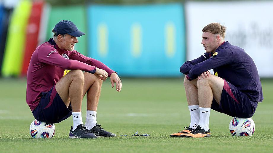 Thomas Tuchel, Head Coach of England, talks to Cole Palmer of during a training session