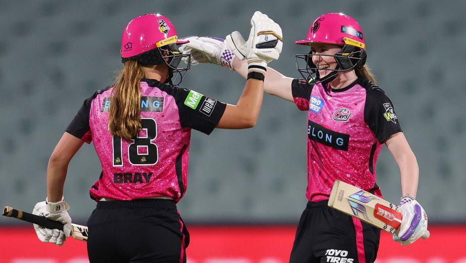 Caoimhe Bray celebrates a victory for Sydney Sixers with Sarah Bryce