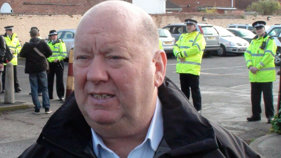 Joe Anderson, former mayor of Liverpool, standing outside the Cricketers Club in Wavertree, during a protest over the BNP basing its operations there in the run up to the 2012 Mayoral Election. Mr Anderson is in the foreground, with police officers standing in the background. 