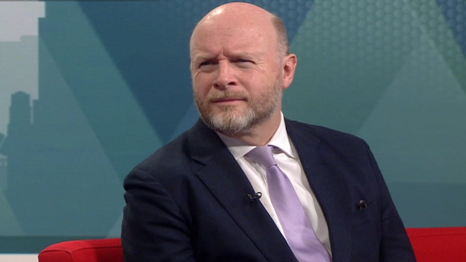 Liam Byrne MP sits in the BBC Politics Midlands studio, wearing a black suit and lilac tie