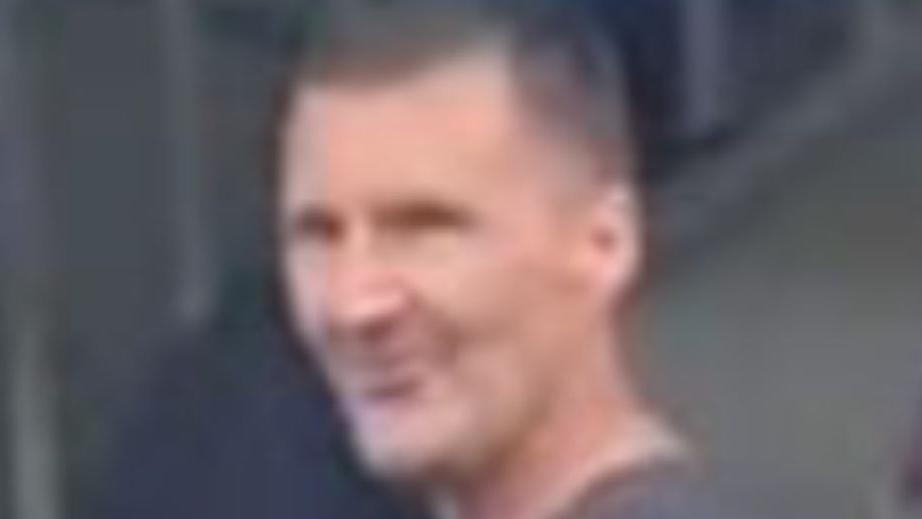 A CCTV image of a man with short dark hair and dark clothing