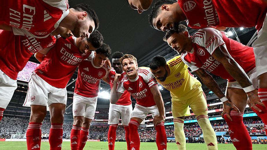 Arsenal players gather round, with Martin Odegaard, centre, talking to the team