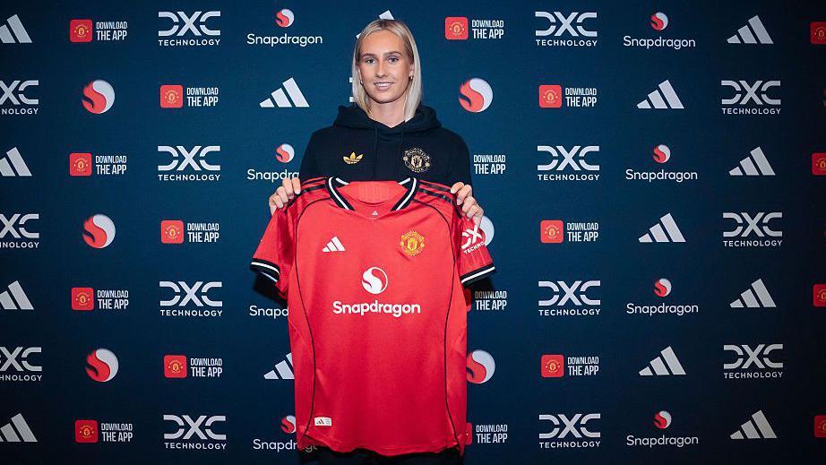 Ellen Wangerheim holds a Manchester United shirt up