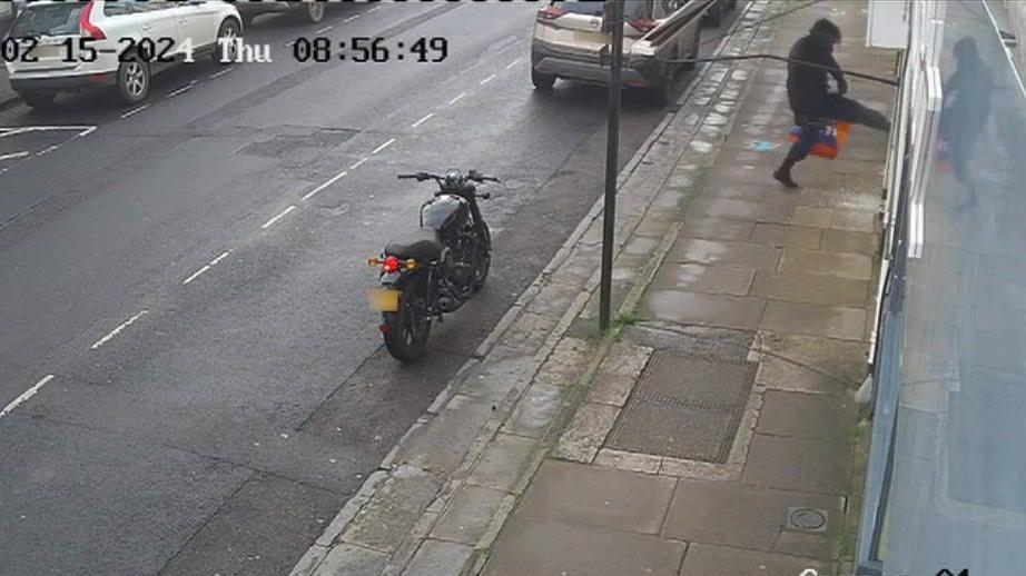 A motorbiker attacks a shop window