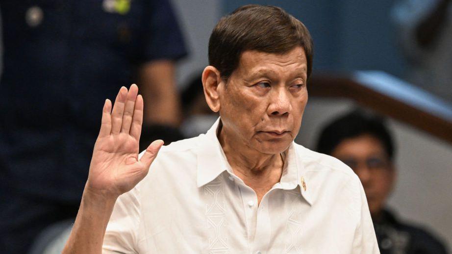 Former Philippine president Rodrigo Duterte takes an oath as he attends a senate probe on the drug war during his administration