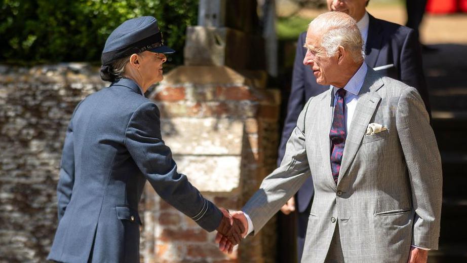 King Charles shaking hands with Ms Petch.