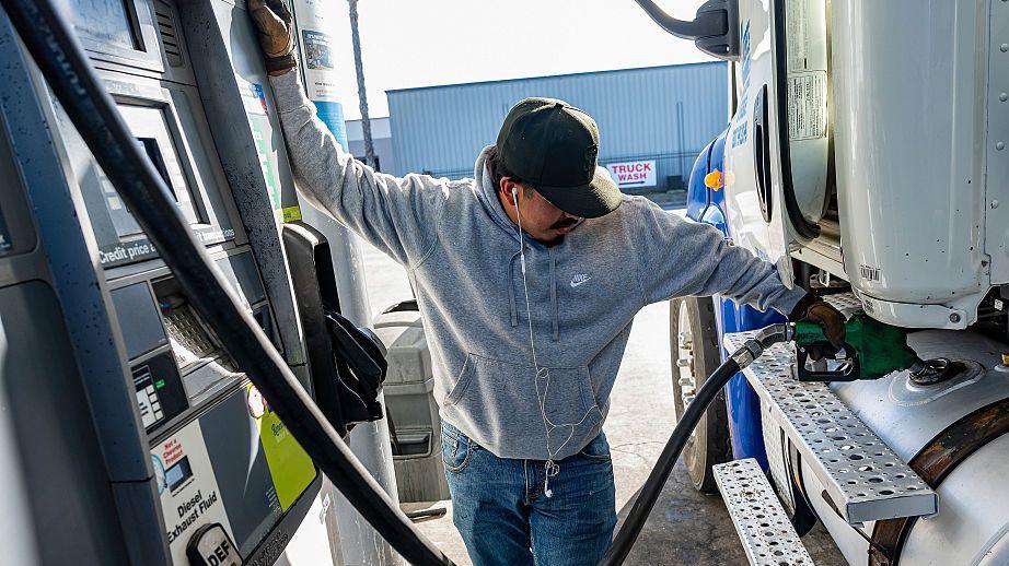 A driver refuels a tractor trailer with diesel fuel while keeping an eye on the nozzle at a Chevron truck stop