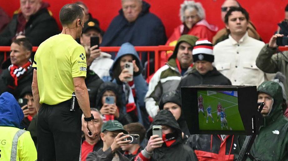 Referee Stuart Atwell watching a video replay