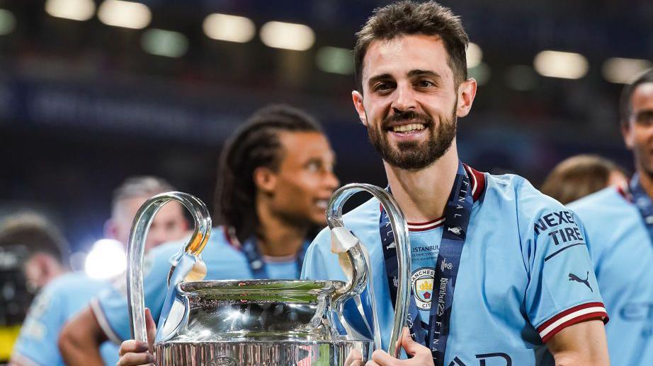 Bernardo Silva holding the Champions League trophy in 2023