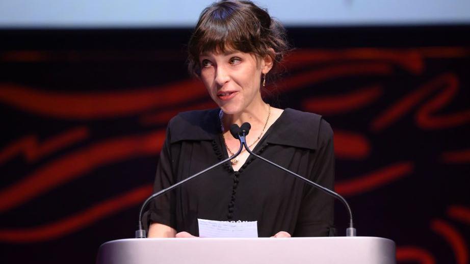 Annes Elwy accepts the Actress Award for 'Bariau' on stage during the 2024 BAFTA Cymru awards 