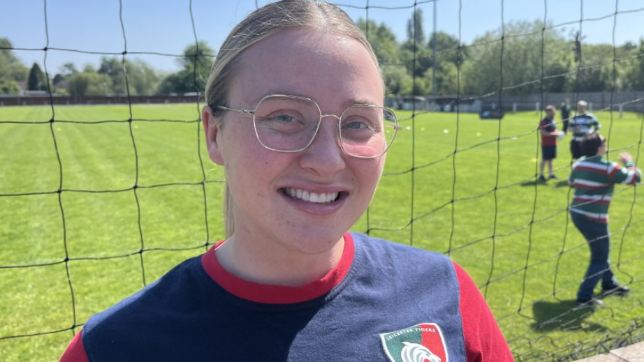 Megan Kirby smiles with the pitch in the backround