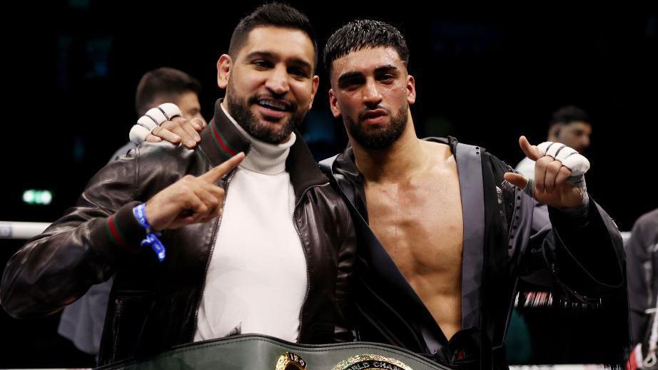 Amir Khan and Adam Azim celebrate in the ring together 