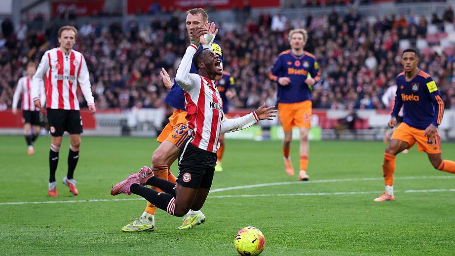Dango Ouattara of Brentford is tripped by Dan Burn of Newcastle United