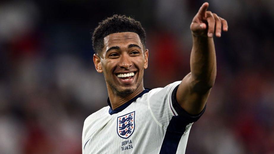 Jude Bellingham smiles and points in England kit