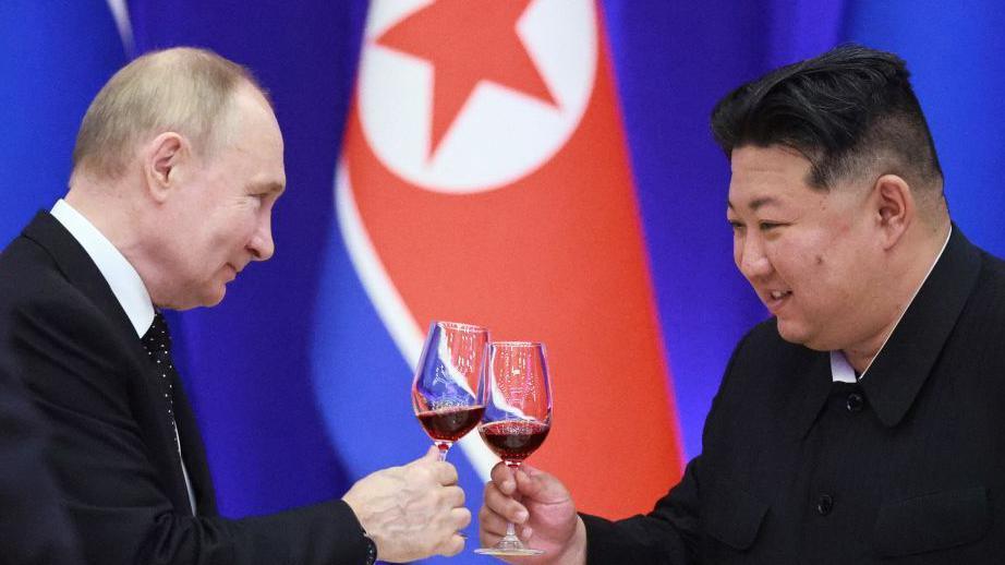 Russian President Vladimir Putin and North Korean leader Kim Jong Un toast during a reception at the Mongnangwan Reception House in Pyongyang