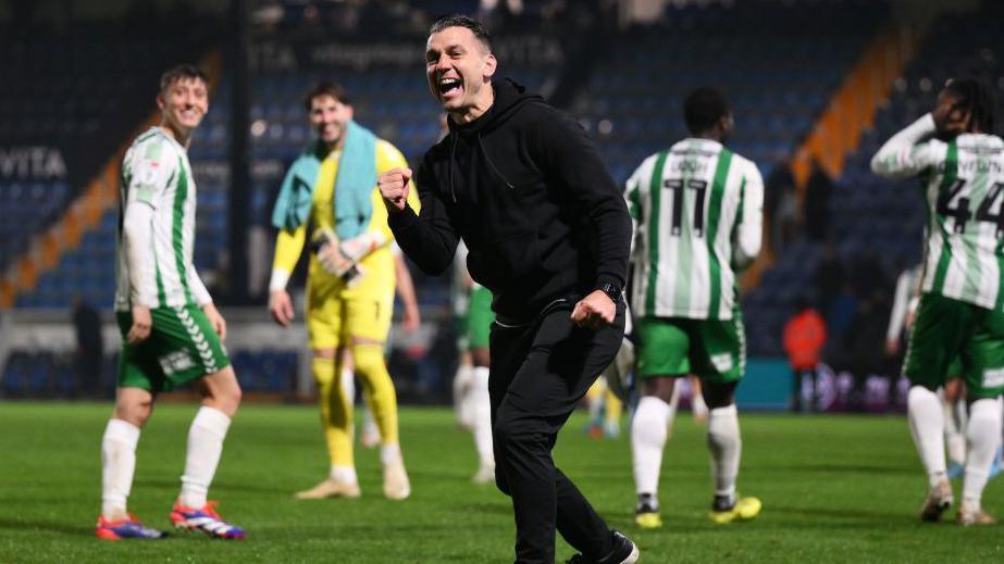 Wycombe manager Matt Bloomfield and his players celebrate in front of the travelling fans 