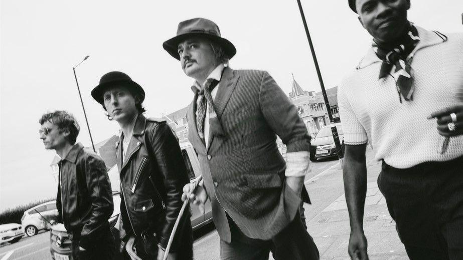 The Libertines are standing side by side in a black and white photo.