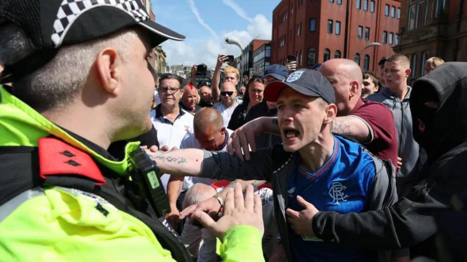 Police officer trying to calm down a protester