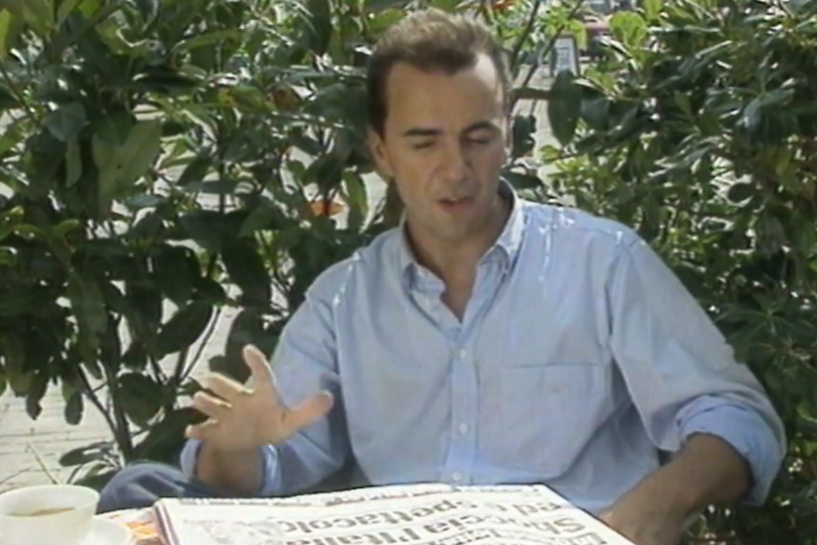 Broadcaster James Richardson sits outside an Italian cafe with a newspaper while presenting Gazzetta Football Italia