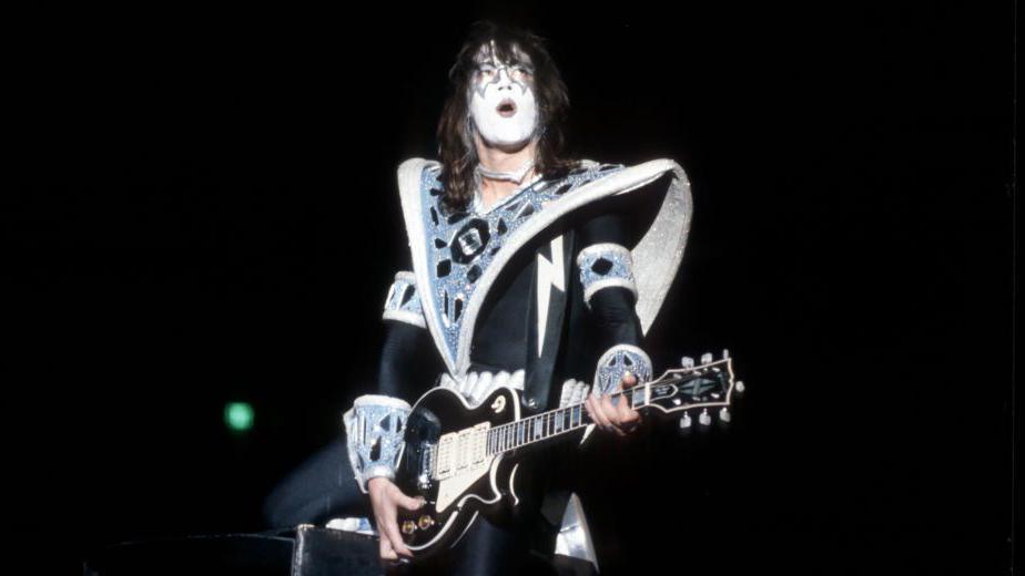 Ace Frehley, in signature black and white KISS make-up, performs on guitar.