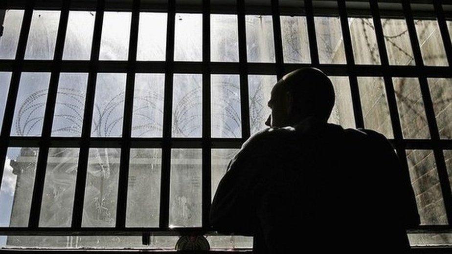 An inmate looking out from prison