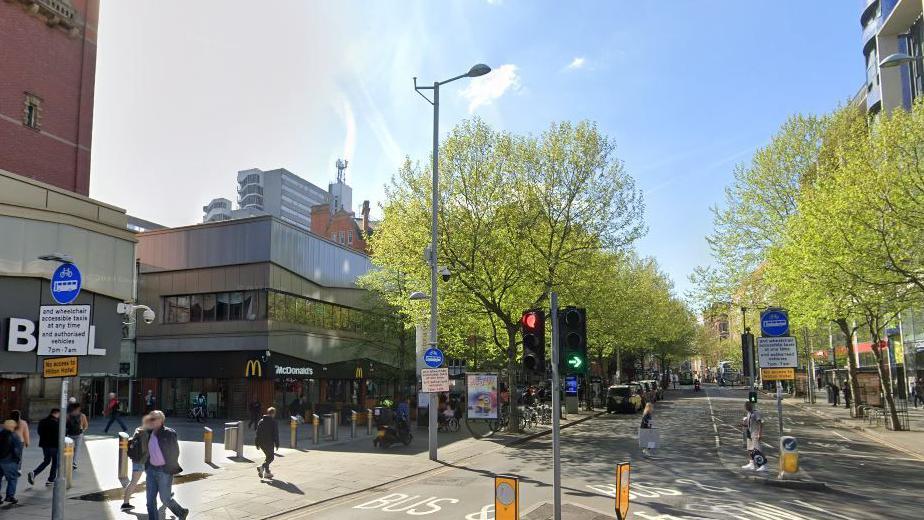 A street level view of Milton Street, showing shops and the width of the road