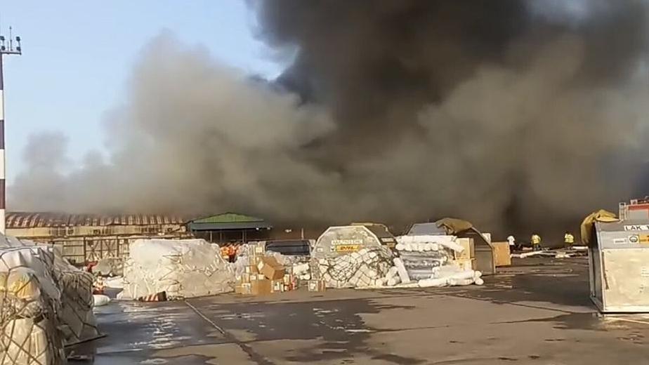 A thick smoke spread across cargo village area after a massive fire broke out where imported goods, including clothes were stored at the Hazrat Shahjalal International Airport in Dhaka, Bangladesh. Heaps of cargo are scattered across the tarmac.
