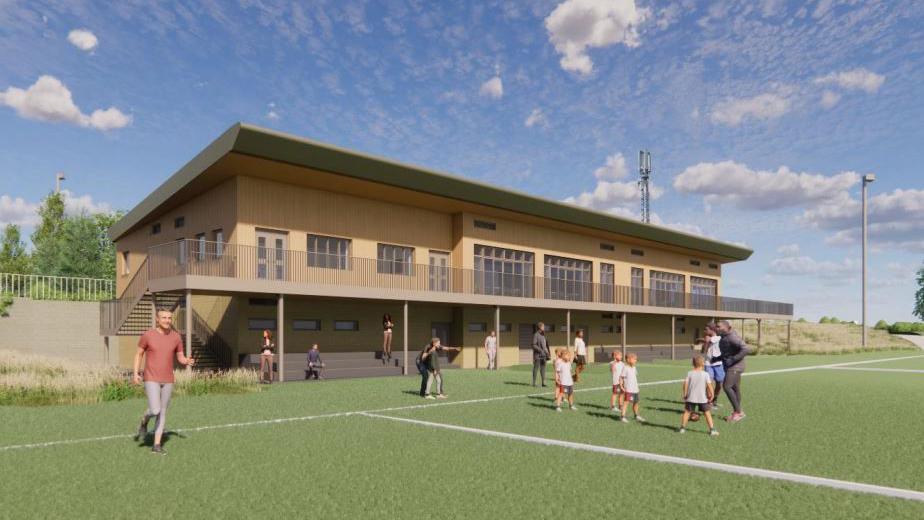 An architect's illustration showing what the new rugby clubhouse would look like. It is a two=-storey building made from wood and has a balcony extending along it. On the pitch are some children being coached, some people standing on the sidelines and a man running.