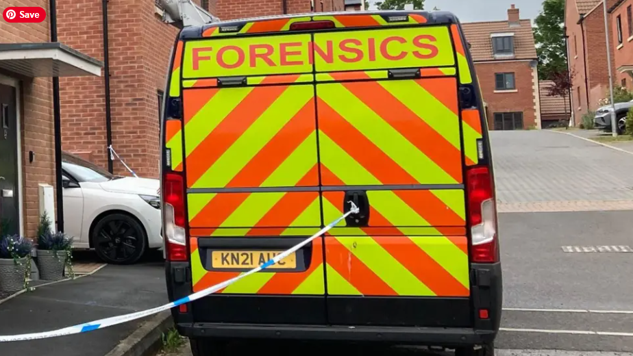 The back of a police van with yellow and orange chevrons and the word 'Forensics' across the top, parked in a housing estate with police tape stretching away from the back door