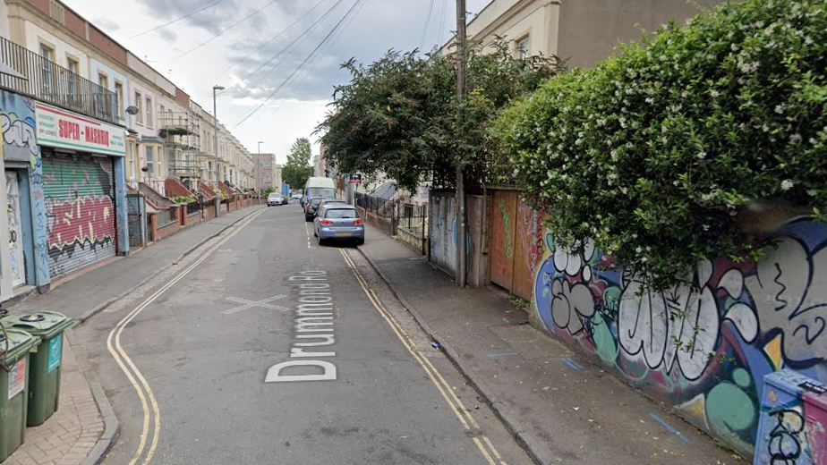 Drummond Road in St. Pauls, Bristol, with graffiti on nearby walls and parked cars 