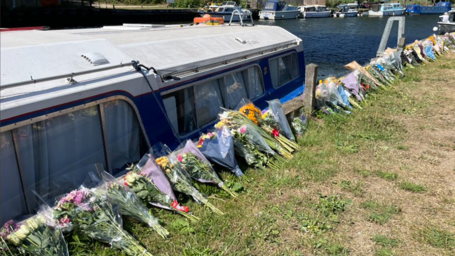 Bouquets of flowers in cellophane on riverbank