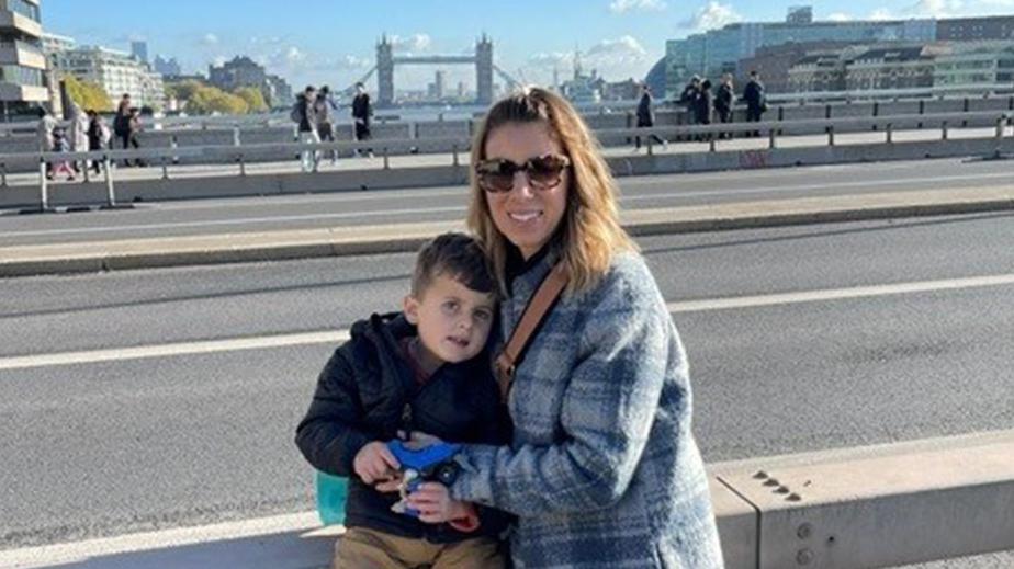 Jace and his mum DJ having their photo taken in London on a sunny day with blue skies, with Tower Bridge in the background