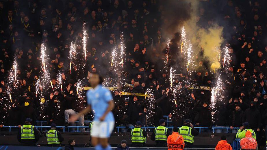 Fans of Young Boys let off fireworks during the Champions League match at Manchester City in 2023