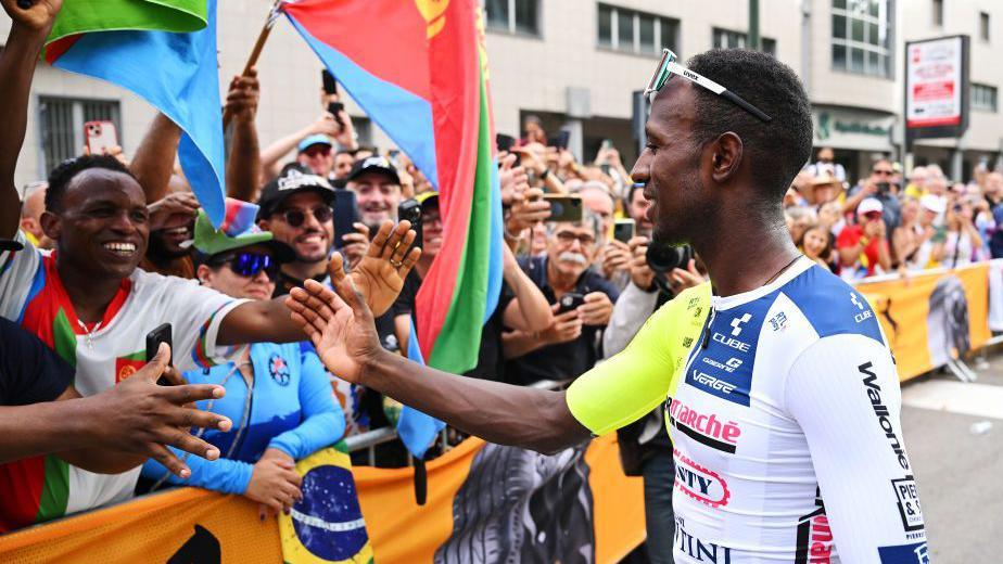 Biniam Girmay greets fans - including ones waving Eritrean flags - at the 2024 Tour de France 