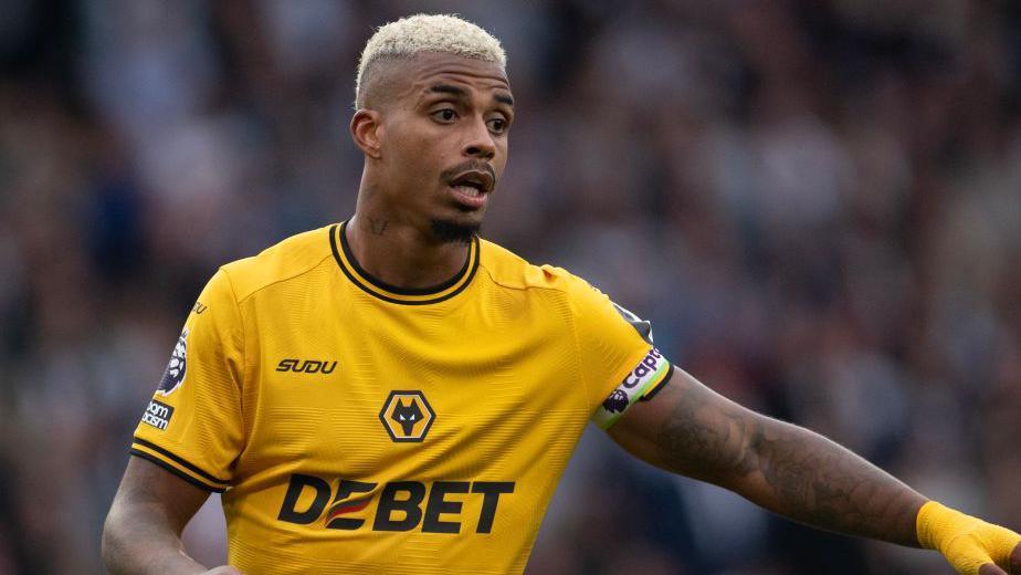 Mario Lemina wearing a Wolves shirt