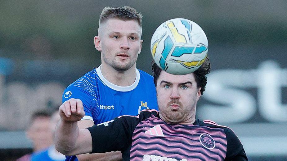 Swifts striker Andrew Mitchell puts pressure on Glenavon's Barney McKeown 