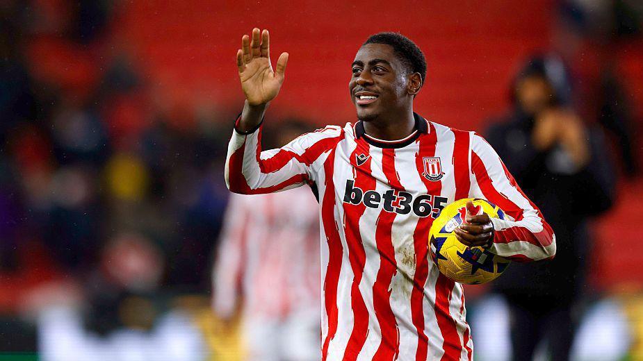 Stoke City striker Divin Mubama waves to the crowd with a ball under his arm after scoring a hat-trick