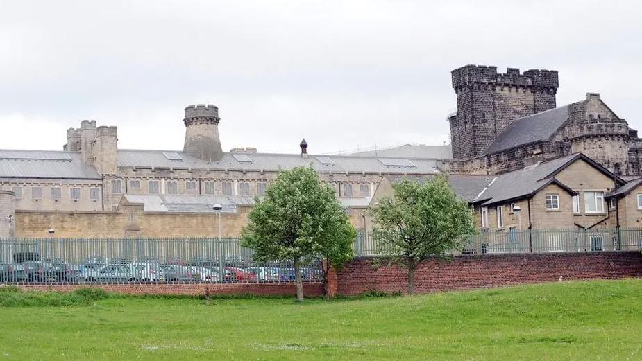 HMP Leeds, a large Victorian building which has railings around it and three turrets coming from the roof.