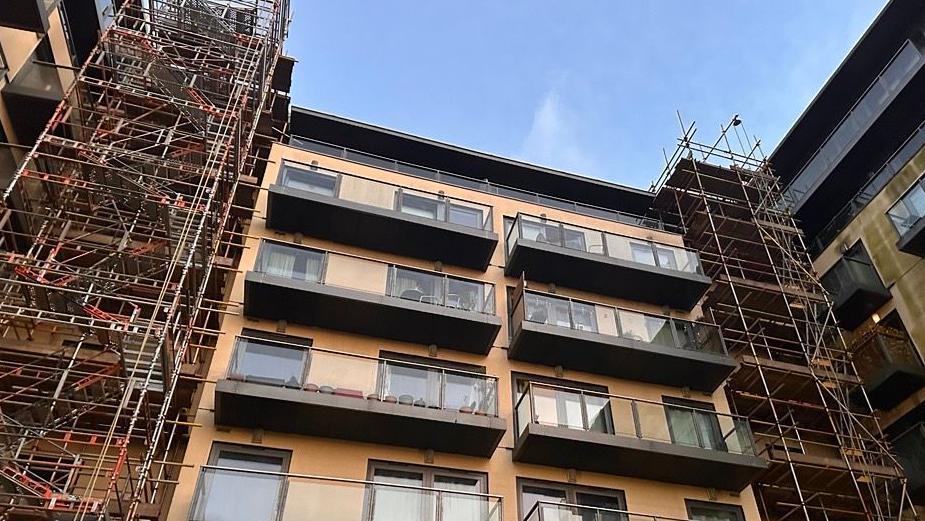 Inside the inner circle of the Mosaic apartment where extensions and construction site is still shown. A number of balconies can be seen on the upper floors of the building with scaffolding down each side where work is continuing.