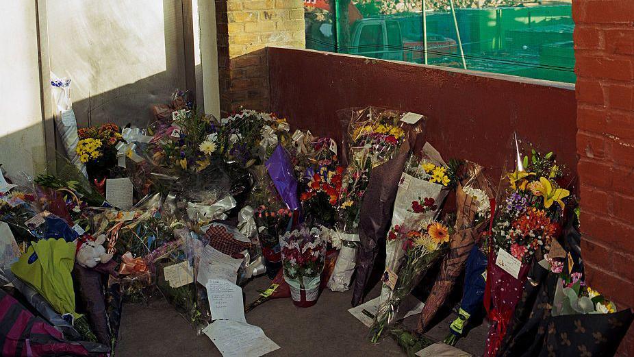 Bouquets of flowers left on a stairwell in the North Peckham Estate.